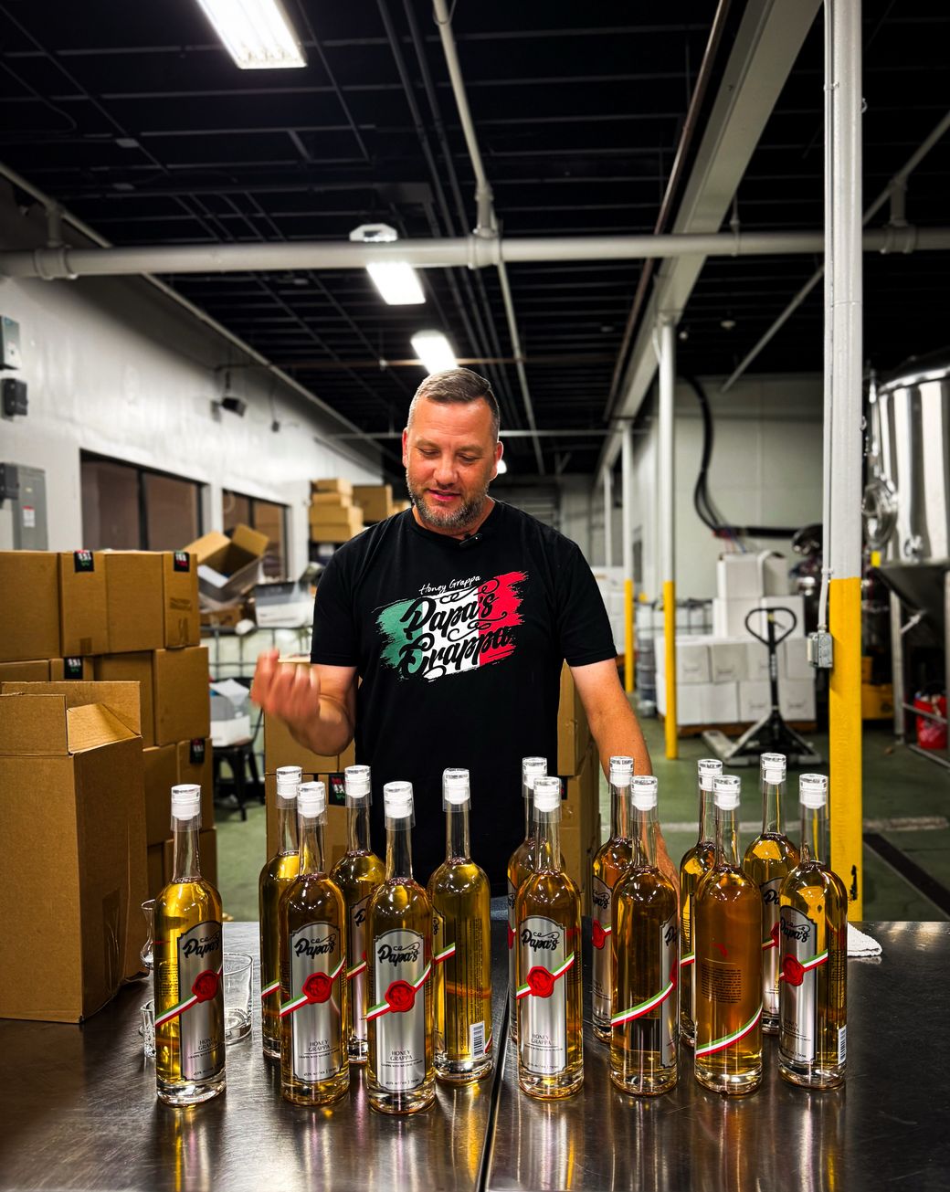 Brian Battle, founder and master distiller of Papa's Grappa, with bottles at the distillery in Miami, Florida